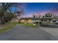 Charming single-story home with a covered carport, well-manicured lawn, and inviting walkway leading to the front door at 330 Gloucester Blvd, Sun City Center, FL 33573