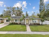 Charming single-story home with a well-manicured lawn and mature landscaping at 605 Gardenia St, Belleair, FL 33756