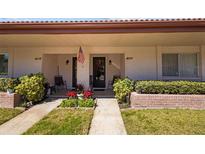 Charming front porch with manicured garden and cozy seating area, perfect for relaxing outdoors at 1102 Montrose Pl # 1704, Dunedin, FL 34698