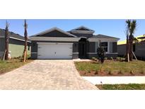 Beautiful home featuring a neatly manicured lawn, paver driveway, and a two-car garage at 17045 James Trl, Parrish, FL 34219