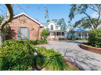 Charming brick and white home with a welcoming front porch and brick driveway on a sunny day at 4315 W Cleveland St, Tampa, FL 33609