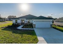 Beautiful single-story home featuring stone accents, manicured landscaping, and a spacious two-car garage at 5433 Chestnut Ridge Rd, Dade City, FL 33523