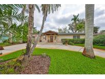 Charming single story home featuring a spacious yard, mature palm trees, and a welcoming entryway at 6791 17Th N St, St Petersburg, FL 33702