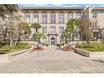 Beautiful exterior of building with multiple large windows, palm trees, and landscaped entrance at 701 Mirror Lake N Dr # 216, St Petersburg, FL 33701