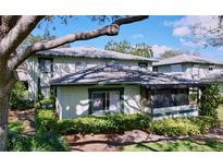 Charming two-story home with green trim, a screened in porch, and well-maintained landscaping at 2904 Lichen Ln # A, Clearwater, FL 33760