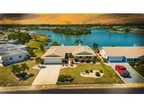 Charming single-story home boasts lush landscaping, a two-car garage, and serene water views at 1504 Valley Forge Blvd, Sun City Center, FL 33573