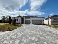 Charming single-story home featuring a three-car garage and paved driveway, perfect for modern living at 17110 James Trl, Parrish, FL 34219