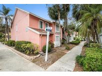 Charming pink condo with lush landscaping and clear signage on a sunny day in a desirable neighborhood at 3600 42Nd S St # 52B, St Petersburg, FL 33711