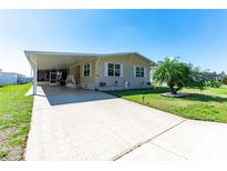 Charming single-story home with neutral siding, carport, and well-maintained landscaping and a concrete driveway at 36838 Tara Ave, Zephyrhills, FL 33542