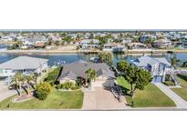 Inviting waterfront home features lush landscaping and a convenient boat lift, set against a charming neighborhood backdrop at 4383 Biscayne Dr, Hernando Beach, FL 34607