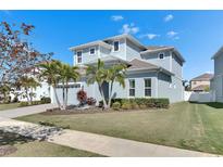 Charming two-story home featuring a well-manicured lawn, palm trees, and an attached two-car garage at 5318 Wishing Arch Dr, Apollo Beach, FL 33572