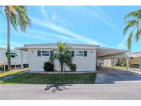 Charming single-story home featuring a covered carport and well-maintained landscaping, under a clear blue sky at 18675 Us Highway 19 N # 217, Clearwater, FL 33764