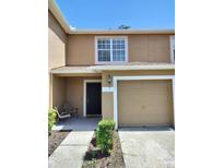 Charming townhome featuring a one-car garage and inviting front porch at 4321 Winding River Way, Land O Lakes, FL 34639