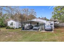 Modest single story home with a three-car carport and grassy front lawn at 8523 Hamster Dr, Zephyrhills, FL 33540