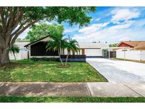 Charming single Gathering home with a well-maintained lawn, lush trees and extended driveway at 10064 82Nd St, Seminole, FL 33777