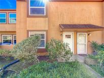 Inviting townhome exterior featuring a well-kept lawn and an attractive covered entrance and white front doors at 1884 Clearbrooke Dr # 1884, Clearwater, FL 33760