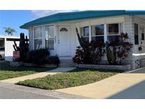 Charming home featuring white siding, teal roof, landscaped yard, and a welcoming front entrance at 2331 Belleair Rd # 527, Clearwater, FL 33764