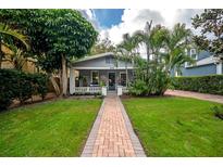 Charming home with lush lawn and brick pathway leading to the cozy covered front porch at 3116 W Wallcraft, Tampa, FL 33611