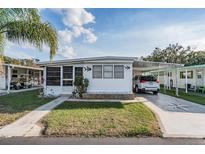 Charming single-story home with a well-maintained lawn and covered parking at 37042 Lois Ave, Zephyrhills, FL 33542