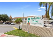 Manhattan Palms Condominiums with manicured grounds and prominent signage in a well-maintained community setting at 7210 N Manhattan # 1822, Tampa, FL 33614