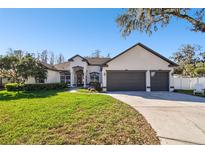 Charming single-story home with a manicured lawn, two-car garage, and a welcoming facade at 1301 Jen Ma Jo Ln, Lutz, FL 33549
