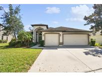 Inviting two-story home featuring a three-car garage and well-manicured lawn at 15721 Starling Water Dr, Lithia, FL 33547