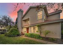 Charming two-story home featuring a well-maintained lawn and inviting red front door at 2180 Clover Hill Rd, Palm Harbor, FL 34683