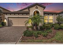 Charming single-Gathering home with a well-manicured front yard and brick paver driveway at 4016 Cadence Loop, Land O Lakes, FL 34638