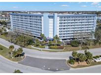 Beautiful ten-story condo building featuring a pool, lush landscaping, and waterfront views at 4939 Floramar Ter # 208, New Port Richey, FL 34652