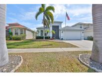Charming home with well-maintained landscaping, palm trees, and an American flag at 5124 Clover Mist Dr, Apollo Beach, FL 33572