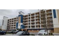 Multi-story condo building featuring multiple balconies, covered parking, and a blue and beige facade at 960 Starkey Rd # 10307, Largo, FL 33771