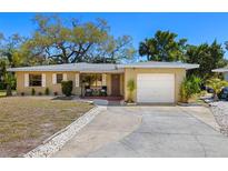 Charming single-story home with a well-maintained lawn, a one car garage, and a cozy front porch at 138 Edgewater Ter, Dunedin, FL 34698