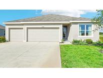 Charming single-Gathering home featuring a manicured lawn and a three-car garage at 17468 Whiskey Creek Trl, Parrish, FL 34219
