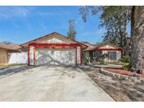 Charming one-story home with a two-car garage, red trim, and well-maintained landscaping at 2717 Warwick Ter, Palm Harbor, FL 34685