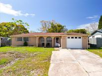 Charming single-story home featuring a large driveway, a one-car garage, and a well-maintained lawn at 5117 School Rd, New Port Richey, FL 34653