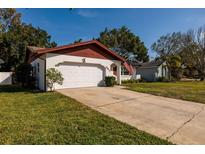 Charming single-story home featuring a two-car garage, well-maintained lawn, and a welcoming entrance at 5611 Venetian Ne Blvd, St Petersburg, FL 33703