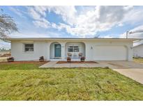 Charming single-story home featuring a well-kept lawn, an attached garage and a quaint front porch at 6333 Spanish Main Dr, Apollo Beach, FL 33572