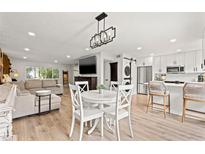 Bright, open-concept living and dining area featuring modern lighting and stainless steel appliances at 10607 Carrollbrook Way # 10607, Tampa, FL 33618
