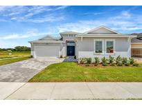 Charming single-story home with a paved driveway, well-manicured lawn, and inviting double-door entryway at 10714 Torchwood Sea Way, San Antonio, FL 33576