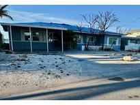 Cozy single-story home with a light blue metal roof and driveway at 1310 Boca Ciega Isle Dr, St Pete Beach, FL 33706