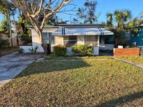 Charming home featuring a quaint front yard with lush greenery and a classic awning at 1835 15Th S Ave, St Petersburg, FL 33712