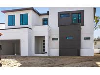 Modern two-story home boasts a sleek white facade with dark accents and large windows, showcasing contemporary design at 3204 W Lasalle St, Tampa, FL 33607