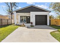 Charming home featuring a modern black and white design, attached garage, and well-maintained lawn at 4440 58Th N Ave, St Petersburg, FL 33714