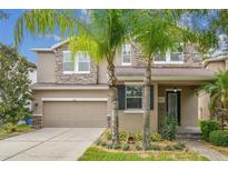 Beautiful two-story home featuring a stone facade, well-manicured lawn, and a two-car garage at 6926 Rocky Canyon Way, Tampa, FL 33625