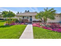 Charming home featuring a well-manicured lawn, vibrant flowerbeds, and a welcoming walkway at 8940 Park Blvd # 8940A, Seminole, FL 33777