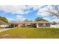 Charming single-story home with a well-manicured lawn and welcoming curb appeal under a sunny sky at 1369 Whitacre Dr, Clearwater, FL 33764