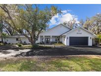 Charming single story home with a covered porch, mature trees and a two car garage at 19242 Blount Rd, Lutz, FL 33558