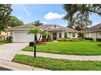 Charming single-story home features a lush lawn, manicured landscaping, and a welcoming front entrance at 2209 Branch Hill St, Tampa, FL 33612