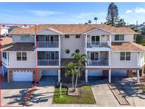 The exterior of the home shows screened balconies, garage spaces, and nicely kept landscaping at 227 126Th Ave, Treasure Island, FL 33706