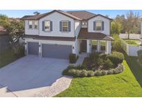 Beautiful two-story home with a well-manicured front yard and three car garage at 23958 Terracina Ct, Land O Lakes, FL 34639